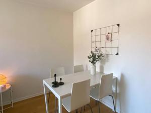 un comedor blanco con una mesa blanca y sillas blancas en Spacious 1 bedroom flat, Lidingo en Kottla