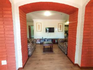 a living room with couches and a red brick wall at 2 Bedroom Self Catering Apartment in Waterkloofridge in Pretoria