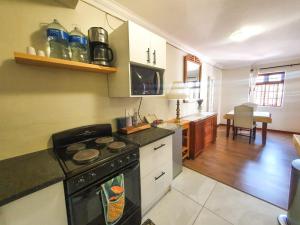 a kitchen with a stove and a counter top at 2 Bedroom Self Catering Apartment in Waterkloofridge in Pretoria