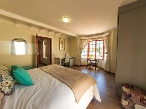 a bedroom with a large bed and a table at 2 Bedroom Self Catering Apartment in Waterkloofridge in Pretoria
