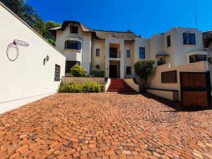 a brick driveway in front of a house at 2 Bedroom Self Catering Apartment in Waterkloofridge in Pretoria