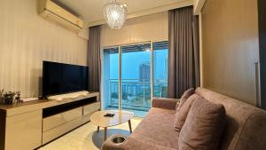 a living room with a couch and a large window at Veranda Residence pattaya By Sea in Jomtien Beach