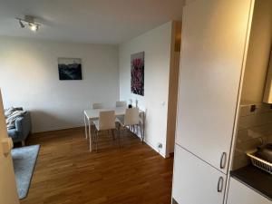 a dining room with a white table and chairs at Cozy 1 bedroom flat on Lindingo in Kottla