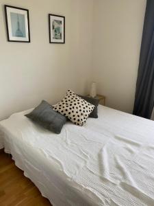 Un dormitorio con una cama blanca con almohadas. en Cozy 1 bedroom flat on Lindingo, en Kottla