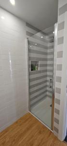 a shower with a glass door in a room at Casa "Patota" - Nazaré - Alojamento Local in Nazaré +15 photos