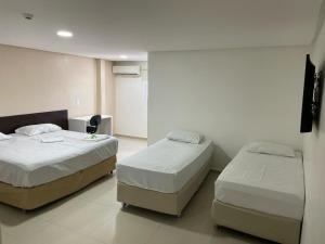 two beds in a room with two beds sidx sidx sidx at Falcão Hotel Arapiraca in Arapiraca
