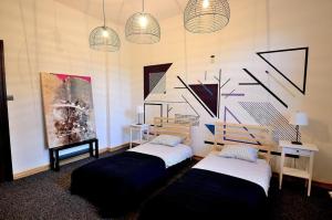 duas camas num quarto com pinturas na parede em Victus Apartamenty, Apartament Flamingo em Sopot
