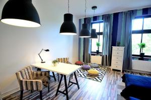 uma sala de estar com uma mesa e duas cadeiras em Victus Apartamenty, Apartament Flamingo em Sopot