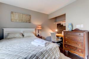 a bedroom with a bed with a desk and a dresser at Renovated Raleigh Bungalow in Raleigh