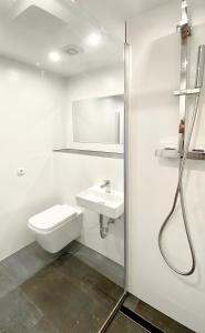 a white bathroom with a toilet and a sink at DOMspitzen-BLICK, cooles 2 Zimmer Apt mit Indoor-Swimmingpool auf dem Dach, Küche und Smart-TV in Cologne