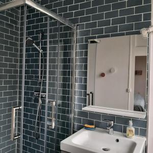 a bathroom with a sink and a shower with blue tiles at ED22 L'Eudoise grande maison de ville in Eu