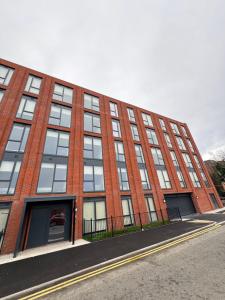 a large brick building with windows on a street at L3 Apartments at Richmond Row in Liverpool