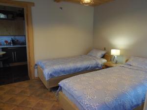 a bedroom with two beds and a bathroom with a window at Dīva in Pāvilosta