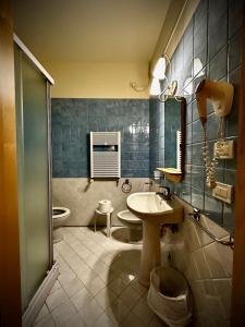 a bathroom with a sink and a toilet and a shower at Hotel Ponte Molo in Porto Tolle