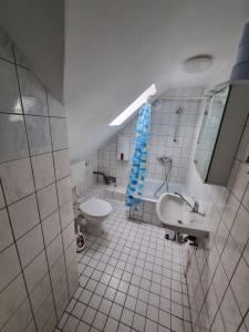 een witte badkamer met een toilet en een wastafel bij Gästewohnung in der Nähe zum CentrO, DGre in Oberhausen