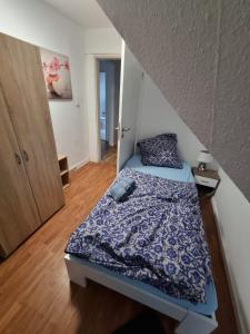 een slaapkamer met een bed met een blauw dekbed bij Gästewohnung in der Nähe zum CentrO, DGre in Oberhausen