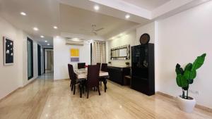 ニューデリーにあるBluO 3BHK - M Block Mkt-Balcony, Lift, Parkingのテーブルと椅子のあるダイニングルーム
