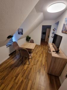 een woonkamer met een houten tafel en een televisie bij Gästewohnung in der Nähe zum CentrO, DGre in Oberhausen