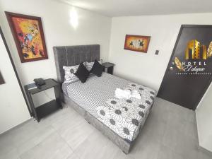 a bedroom with a bed with a black and white comforter at Hotel el Duque Internacional in Bogotá