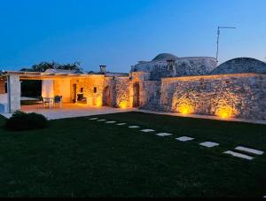 een huis met een stenen muur en een tuin bij Trullo Al Guappo d'Oro in Ostuni