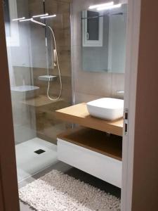ein Bad mit einem Waschbecken und einer Glasdusche in der Unterkunft Maison moderne à 2 pas des plus jolies plages ! in Saint-Pabu