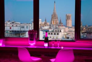 a bar with pink chairs and a view of a city at Enjoybcn Plaza Catalunya Apt. in Barcelona