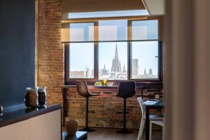 een kamer met een tafel en stoelen en een groot raam bij Enjoybcn Plaza Catalunya Apt. in Barcelona