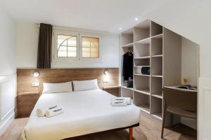 - une chambre avec un grand lit blanc et un bureau dans l'établissement Enjoybcn Plaza Catalunya Apt., à Barcelone