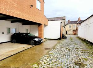 a black car parked in front of a garage at Apartment 1 Exquisite two king bedroom with en suites - close to the town centre, rail, airport and theatre in Darlington