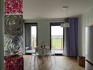 a kitchen with a table and chairs in a room at Warsaw Airport Wyścigi - City and Green View Apartment with free parking in Warsaw
