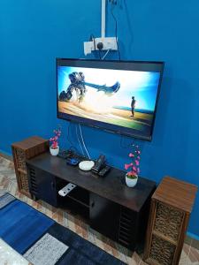 a large flat screen tv sitting in a living room at SR KAMPAR HOMESTAY in Kampar