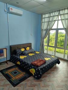 a bedroom with a bed in a room with a window at SR KAMPAR HOMESTAY in Kampar