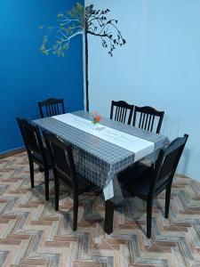 a dining room table with four chairs and a tree at SR KAMPAR HOMESTAY in Kampar