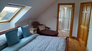 a bedroom with a bed and a chair and a window at Country Lane Homestay in Westport