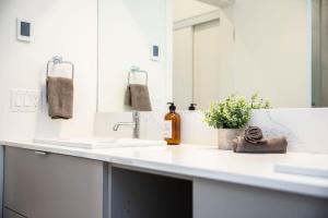 a bathroom counter with two sinks and a mirror at Domino Condo - Bunk Bed & Hot Tub in Revelstoke +22 photos