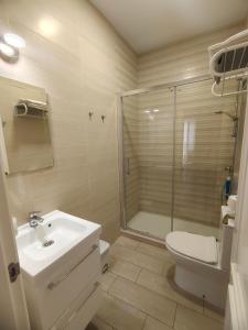 Un baño con inodoro, lavabo y ducha. en La Viña (centro histórico), en Cádiz