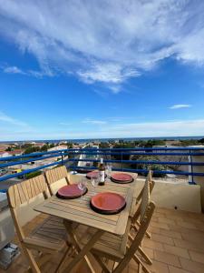 une table et des chaises en bois sur un balcon dans l'établissement 180 panoramic terrace, à Frontignan
