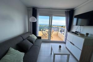 un salon avec un canapé et un balcon dans l'établissement 180 panoramic terrace, à Frontignan