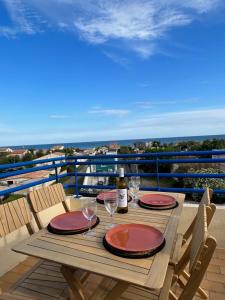 - une table avec une bouteille de vin et des verres sur un balcon dans l'établissement 180 panoramic terrace, à Frontignan