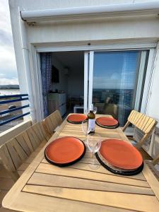 une table avec des assiettes orange et des verres à vin sur un balcon dans l'établissement 180 panoramic terrace, à Frontignan 15 autres photos