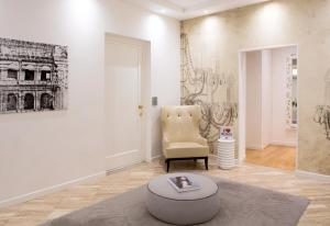 a living room with a chair and a ottoman at Via Del Corso Home Roma in Rome +43 photos