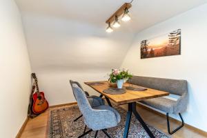 a dining room with a table and chairs and a guitar at Fewo Straub in Freudenstadt