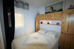 um pequeno quarto com uma cama com lençóis brancos em The sea within sight em Frontignan