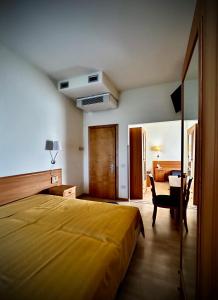 a bedroom with a large yellow bed and a desk at Hotel Ponte Molo in Porto Tolle