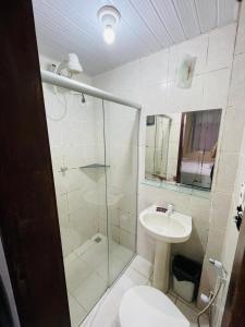 a bathroom with a shower and a toilet and a sink at Hotel Netuno Beach in Fortaleza