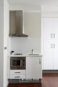 a kitchen with a stove and a microwave at MyHouseSpain - Apartamentos Moros 41 in Gijón