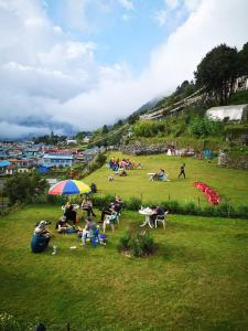 een groep mensen die op een grasveld zitten bij Lukla Himalaya Lodge in Lukla