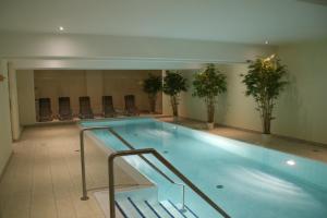 a large swimming pool in a building with chairs at Modernes Appartment, 3 Gehminuten zum Strand, Pool+Sauna in Zempin