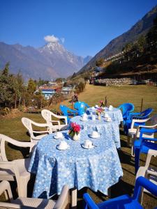 un groupe de tables bleues et blanches avec des fleurs sur elles dans l'établissement Lukla Himalaya Lodge, à Lukla