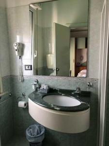 een badkamer met een wastafel en een spiegel bij HOTEL AUGUSTUS in Gatteo a Mare